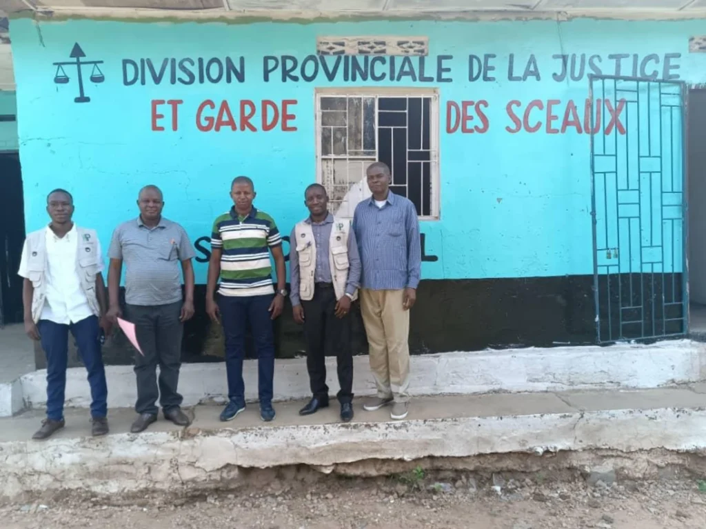 Équipe devant un bâtiment de la justice